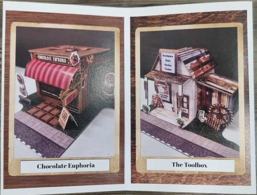 Miniature storefronts for Chocolate Euphoria and The Toolbox, featuring candy decor and rustic tool-themed elements. These are other buildings in this range. 