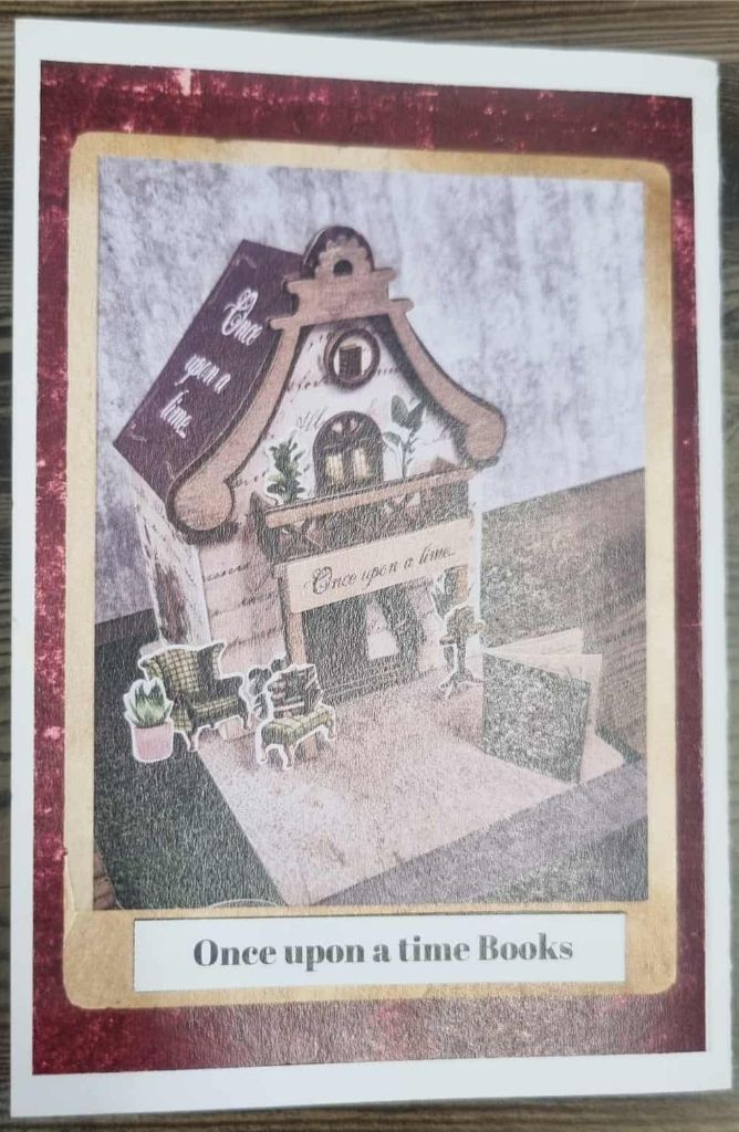 Miniature bookshop titled “Once Upon a Time” with cozy reading nook decor and armchairs.